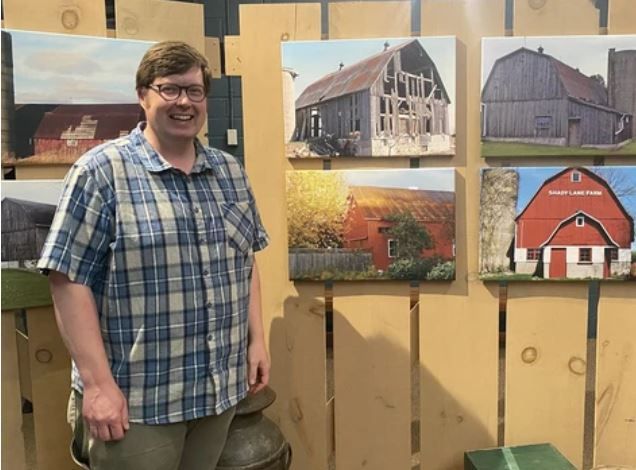 Waterford Curator stands next to display from Barn Exhibit